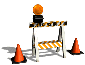 a sign that says 'under construction' on it. There are two traffic cones beside it on either side and a blinking light above it